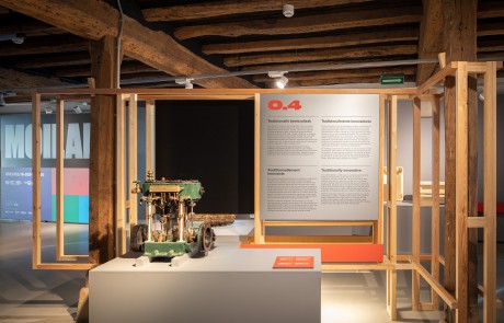 Imagen de la primera planta de la exposición Moilak. Tradicionalmente innovadores. En la fotografía se ve la primera planta del museo con el cartel de bienvenida de la exposición y un motor que se exhibe en la muestra.