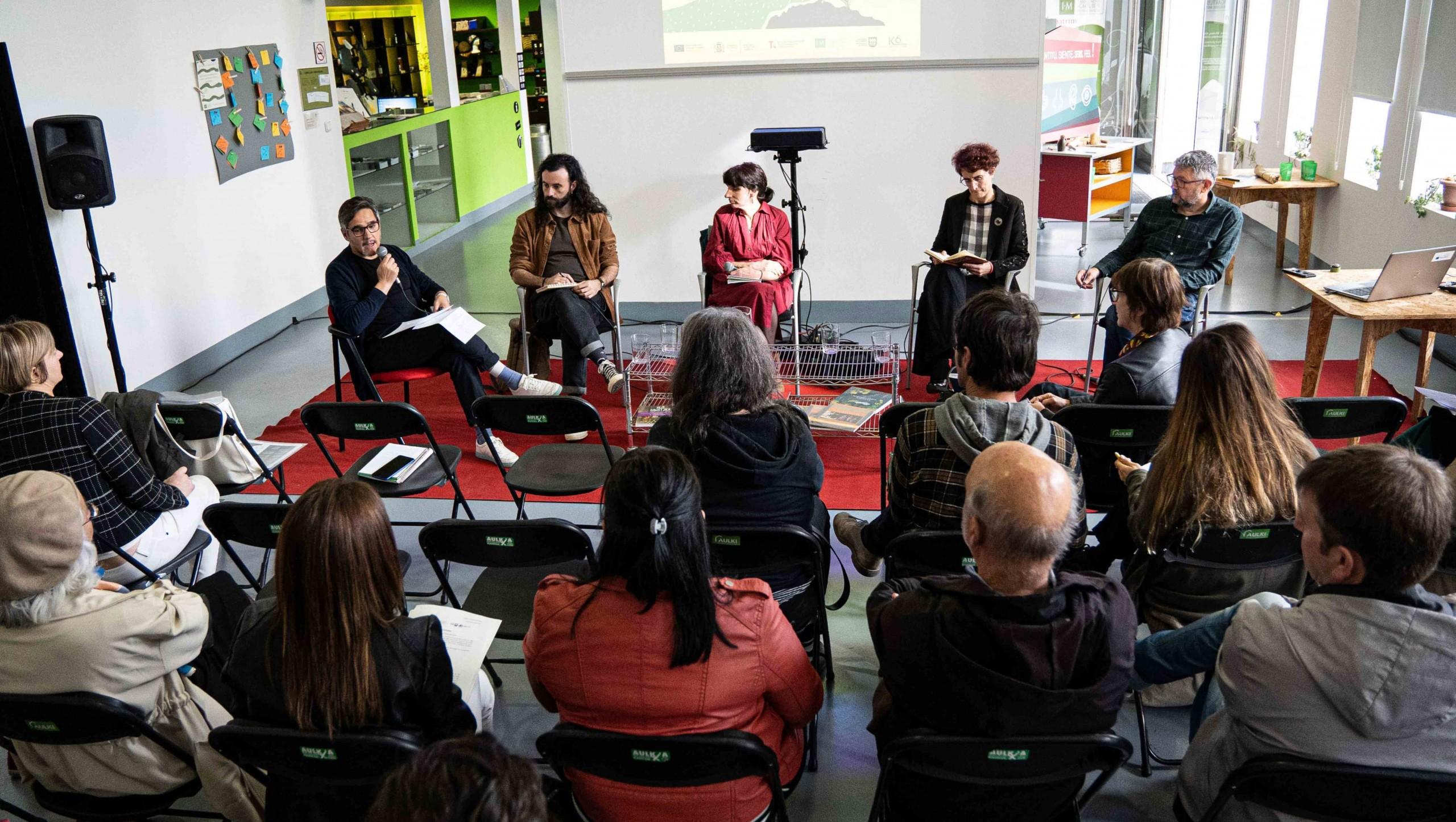 Mesa redonda de los reencuentros sobre arte, territorio y ruralidades con varias personas escuchando a las cuatro personas que hablan