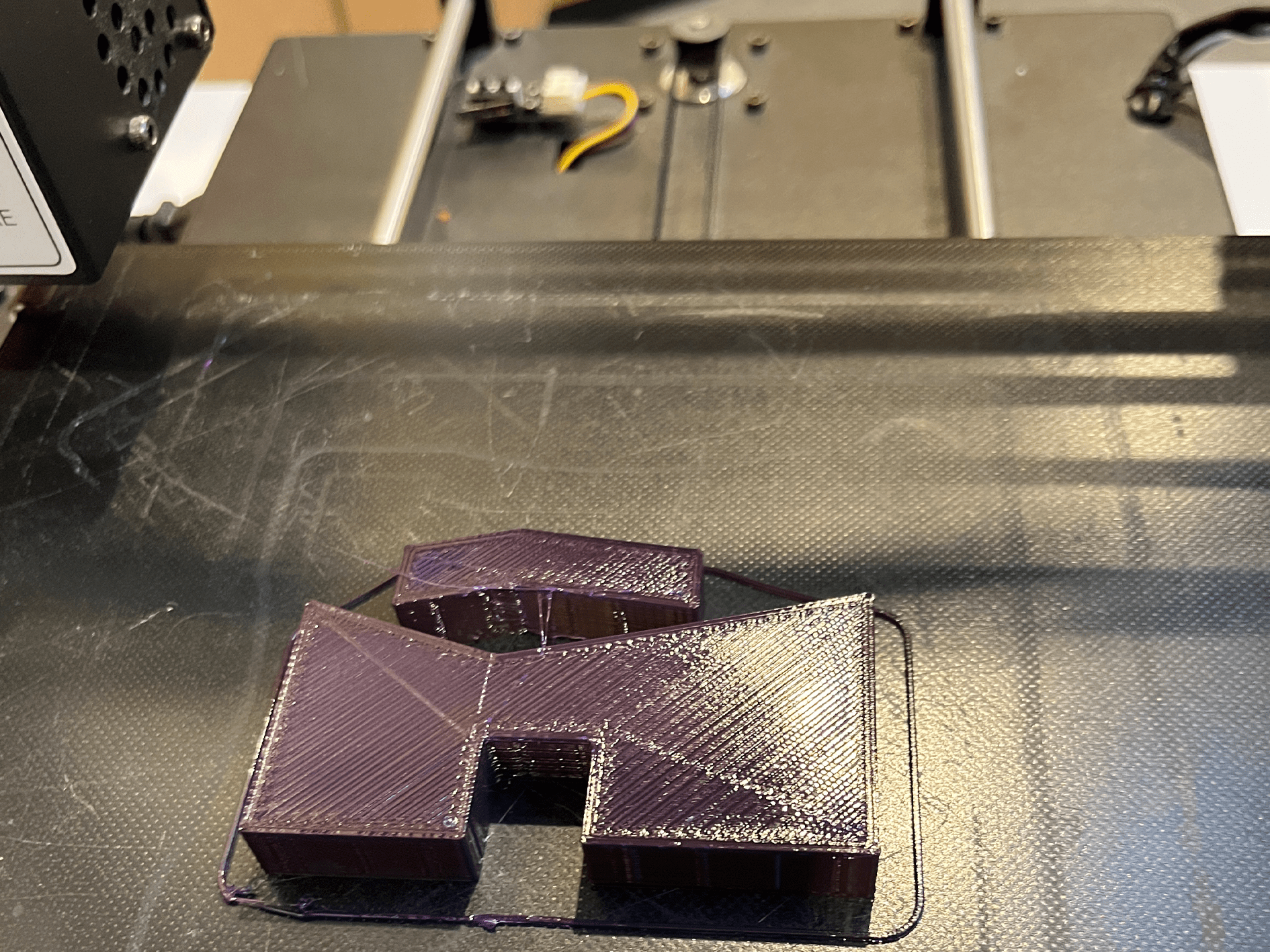 Una impresora 3D imprimiendo un el logo de museum cemento rezola